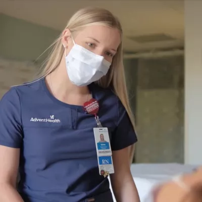 Nurse looking at patient in bed