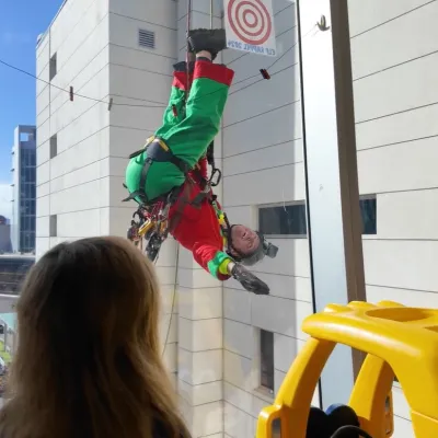 A deputy dressed as an elf rappels from the children's hospital roof to wave to patients inside.