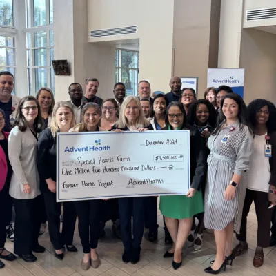 Representatives from Special Hearts Farm and AdventHealth pose with a giant check for $1.5 million.