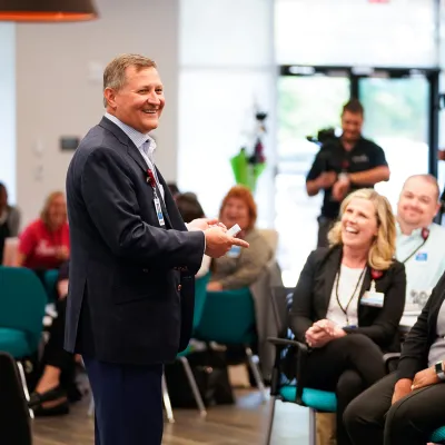Terry Shaw addressing AdventHealth Employees with a smile.