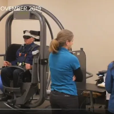 Man straps into vertigo chair as therapists monitor