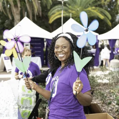 Smiling woman holding floral decoration at Walk to End Alzheimer's