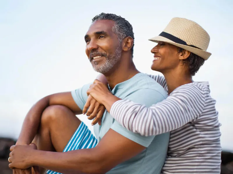 A woman hugging her male partner from behind