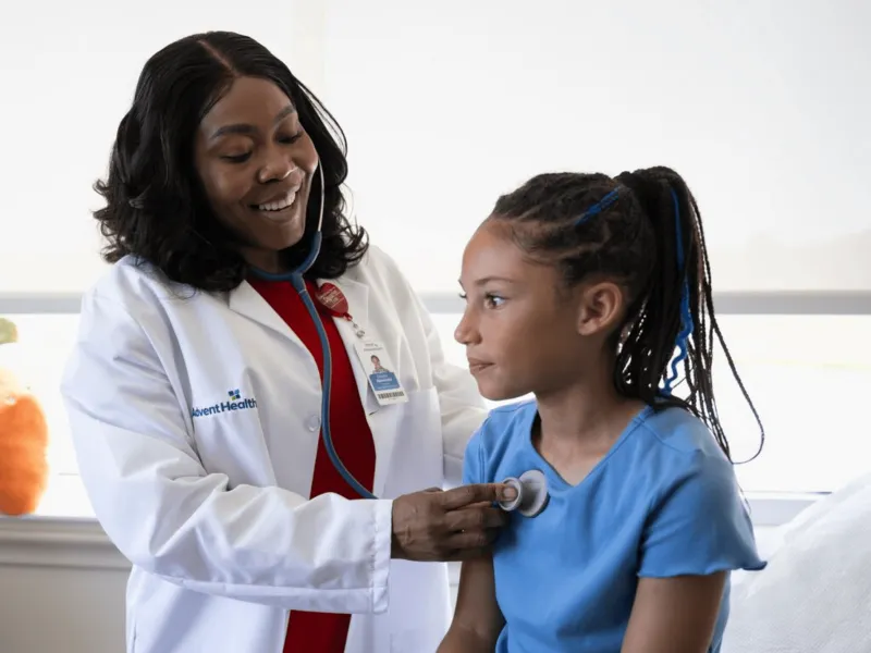 A Physician Checks Her Child Patient's Breathing with a Stethoscope 