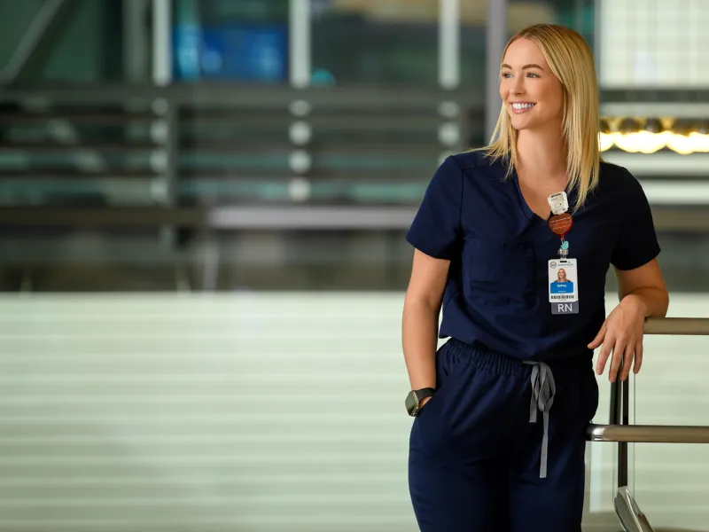 A Nurse Leans on a Railing Smiling