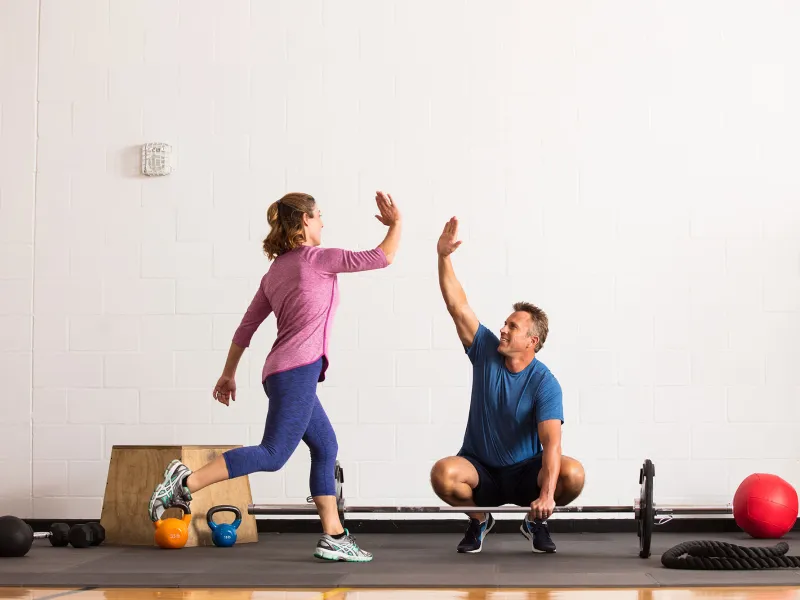 A couple giving each other high five while working out.