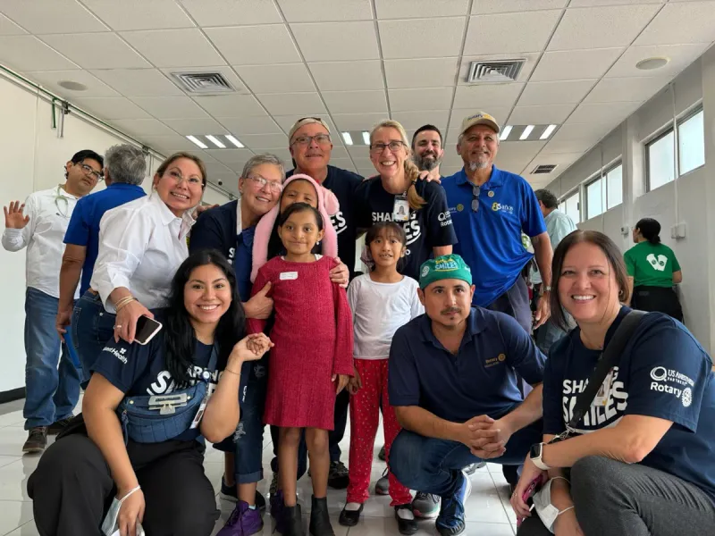 A group of Sharing Smiles volunteers with a child