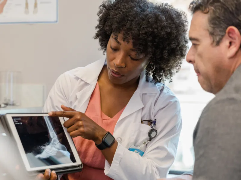 Doctor showing a man an x-ray of his foot.