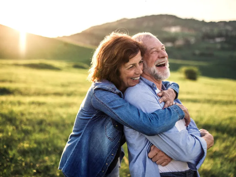 A senior couple enjoying their time together while at grassy plains