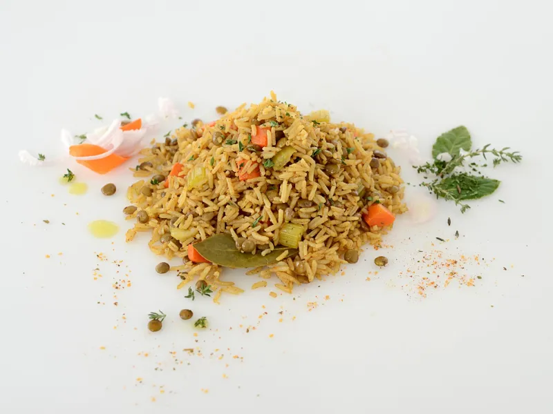 a pile of cooked rice, mixed with diced carrots, onions, celery and lentils