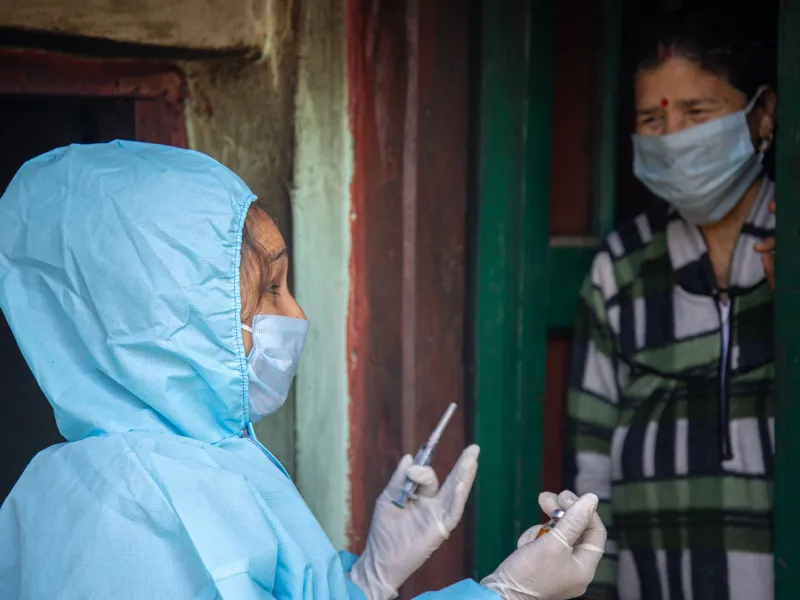 a healthcare worker with a needle and a patient