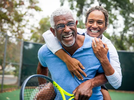 woman hugging man with tennis racket