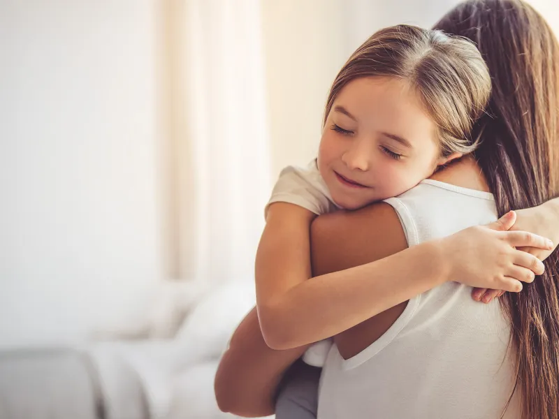 Young child embracing her mother