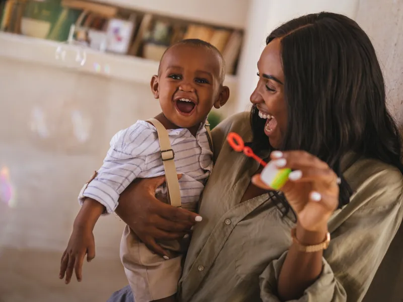 A mom entertaining her baby with bubbles.