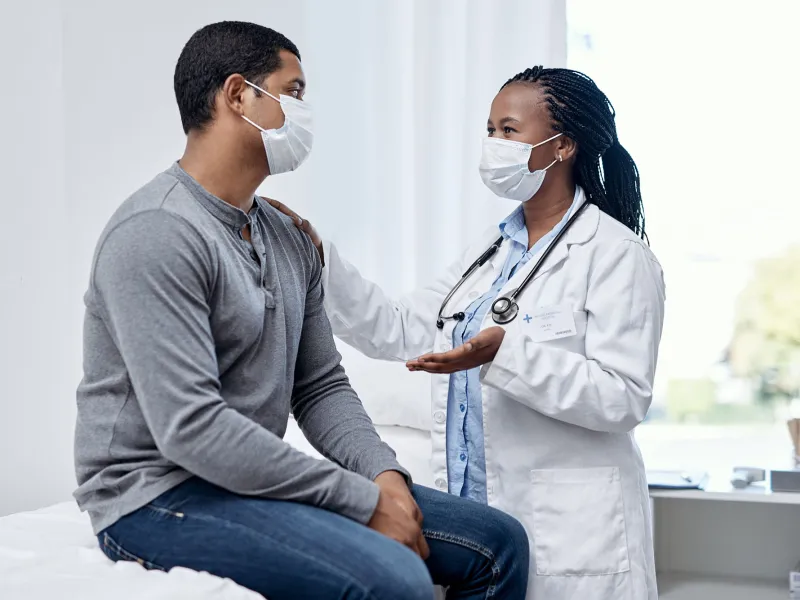 A physician discussing something to her patient