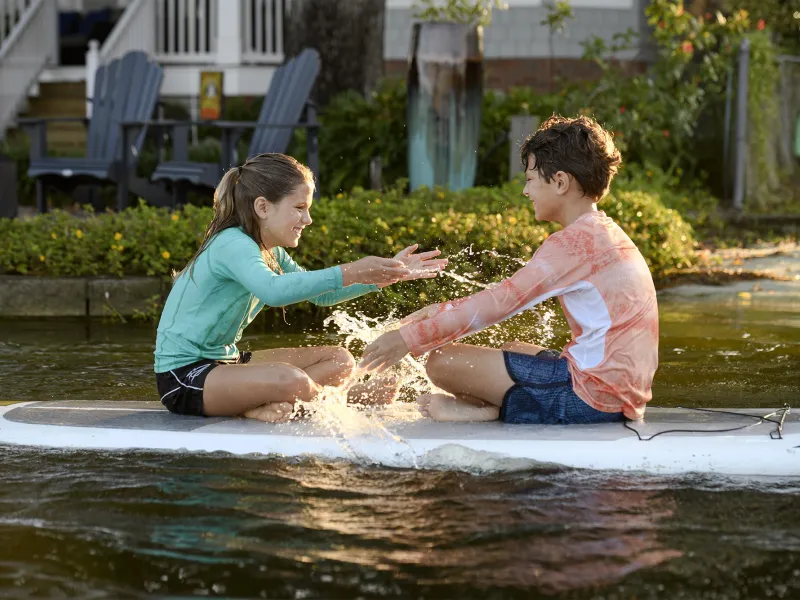 Kids on a Paddleboard splashing water.