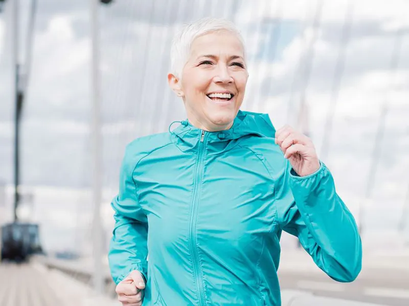 a-woman-running-outdoors-and-smiling