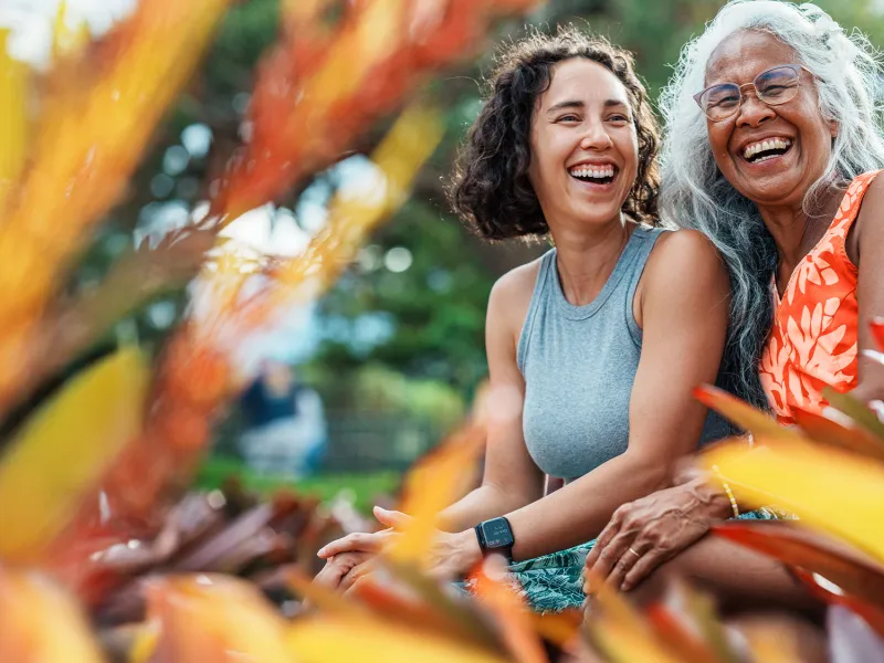 mom and daughter smiling in a garden