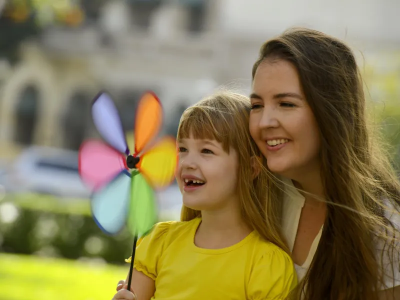 Mom and daughter playing with a pinwheel.