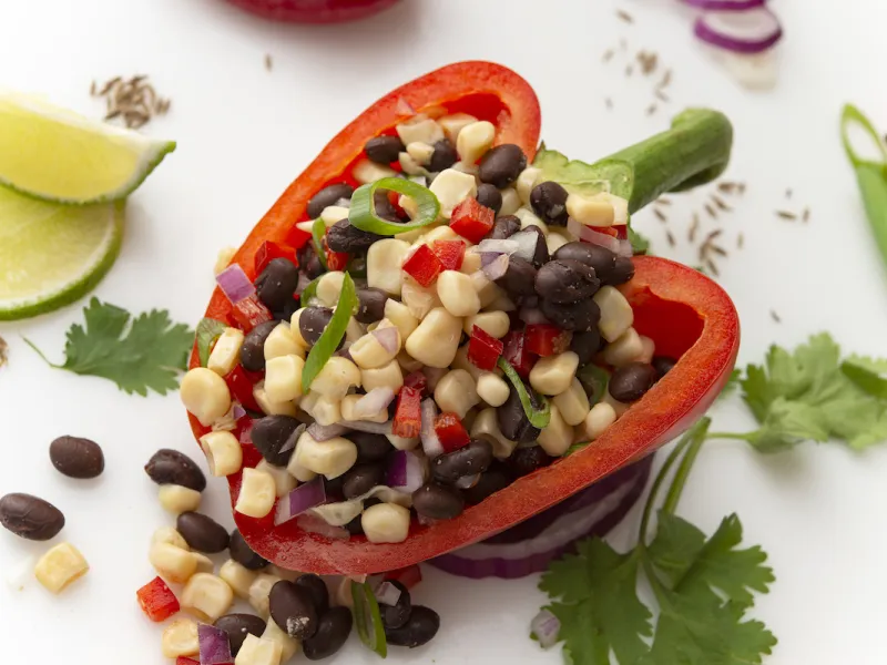 Half of red bell pepper stuffed with bean/corn salsa with lime garnish
