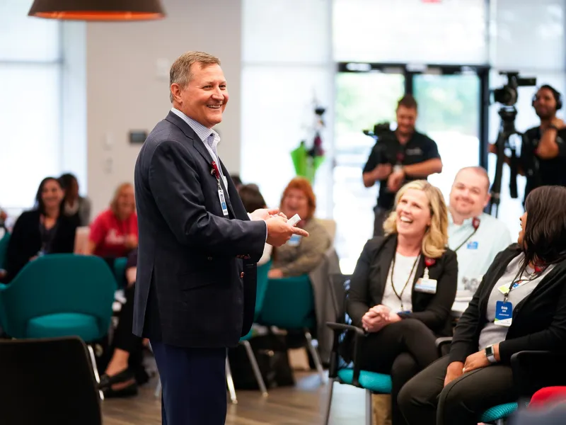 Terry Shaw addressing AdventHealth Employees with a smile.