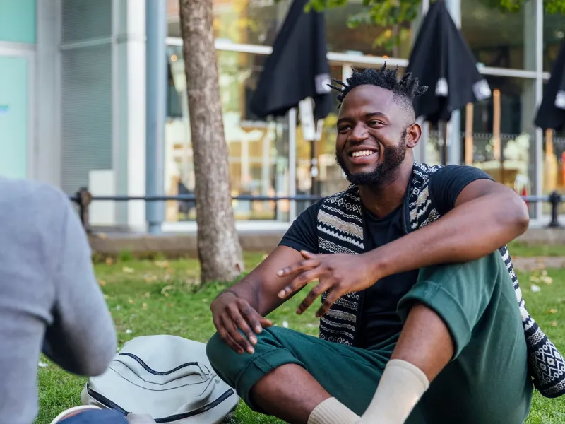 Two young men sitting outside social distancing