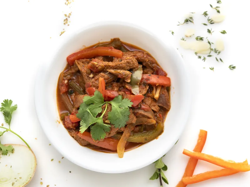 Bowl of ropa vieja stew with parsley and carrot garnishes