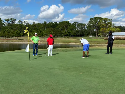 Golfer putting ball on green