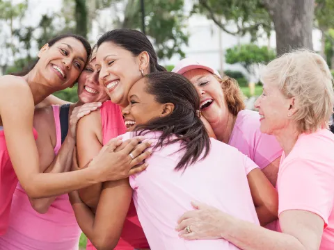 women wearing pink shirts and hugging
