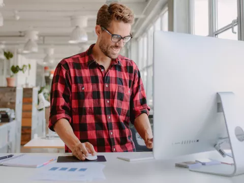 A man using a standing desk while working