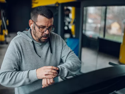 Man on a treadmill checking his watch