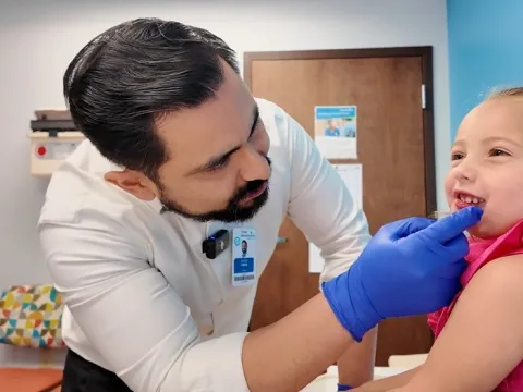 Dr. Joseph Lopez examines the mouth of a little girl named Madi, who had a cancerous tumor in her jaw.
