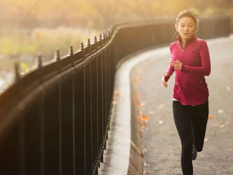 woman running on a path next to a lake