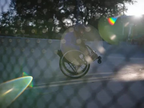 Man in a wheelchair doing a wheelie