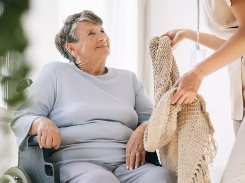 Ederly woman taking blanket from nurse