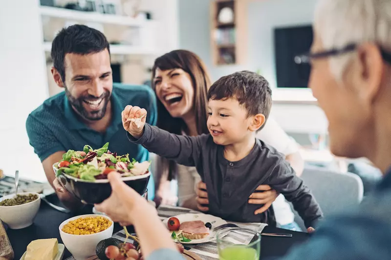  A Family Gathers Around The Kitchen Table To Enjoy Some Healthy Foods.