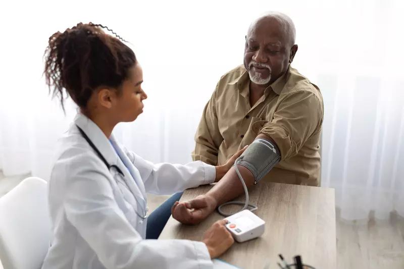 A Doctor Takes a Patient's Blood Pressure with a Blood Pressure Cuff