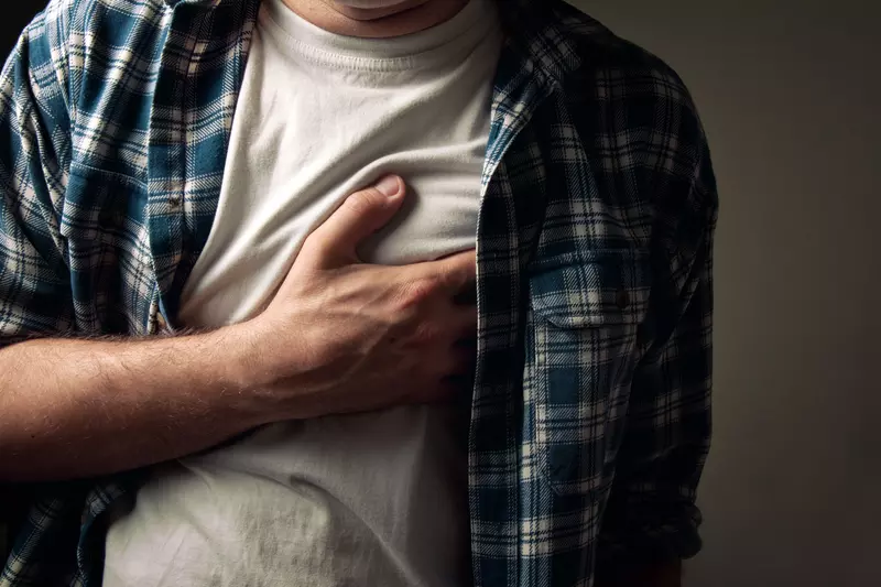 Man clutching his chest.