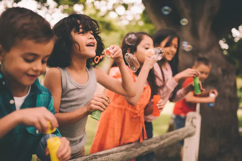 A group happy children blowing bubbles during the summer.