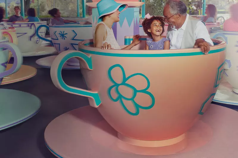 Family having fun on the tea cup ride at Disney.