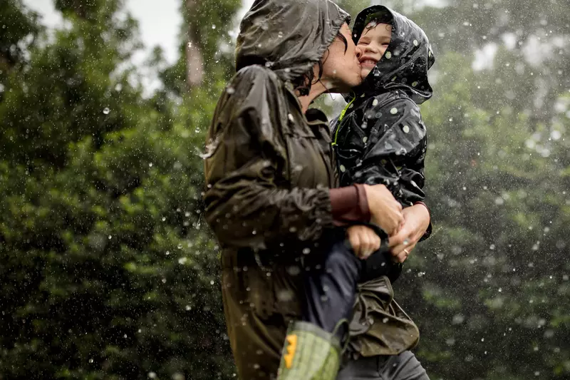 Mom and little boy playing in the rain.