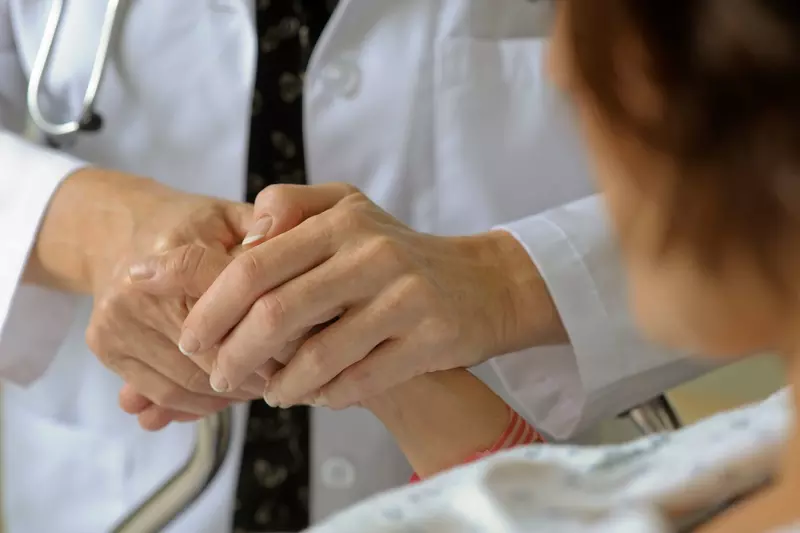 Physician holding hands with patient