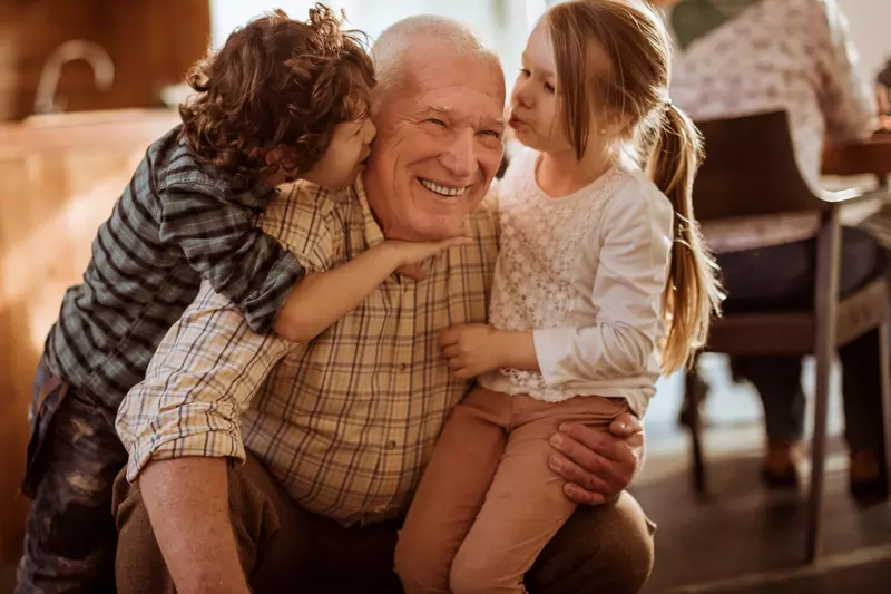 A grandfather plays with his grandchildren.