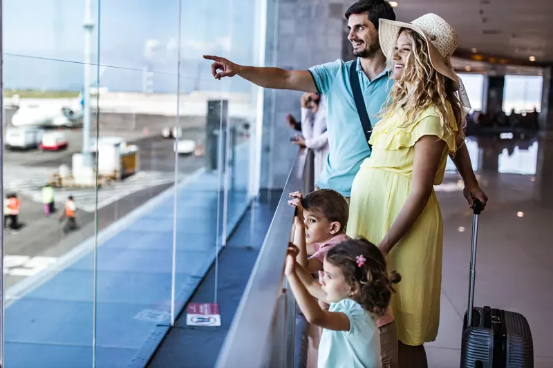 A family watches planes at the airport together.
