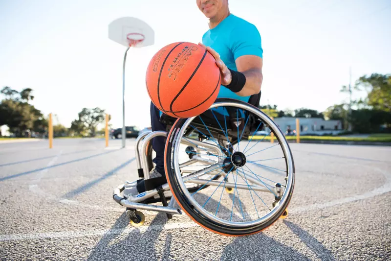Man playing basketball in a wheelchair.