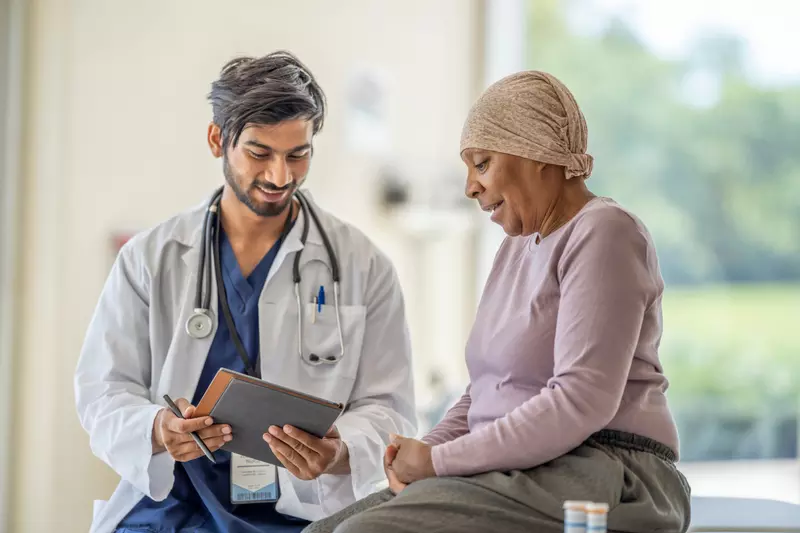 Doctor explaining to an older woman cancer patient her test results.