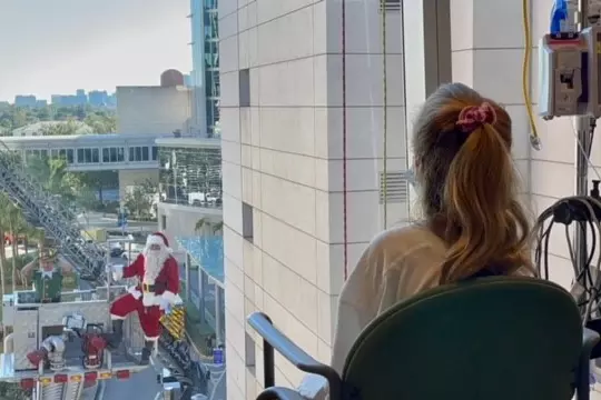 A young patient spots Santa outside her window at AdventHealth for Children. 