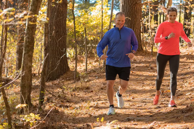 A Middle Aged Couple Goes For a Jog Through a Wooded Trail.