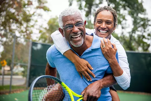 woman hugging man with tennis racket