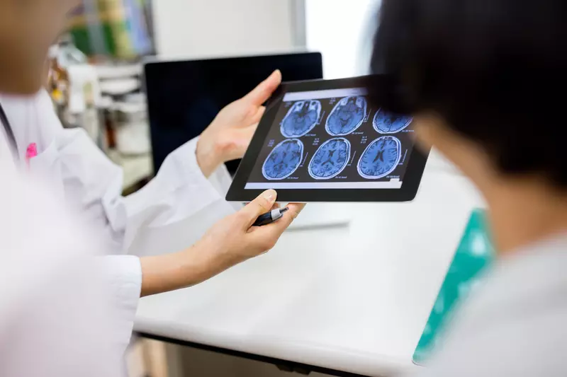 A hospital care team reviews scans of a patient's brain